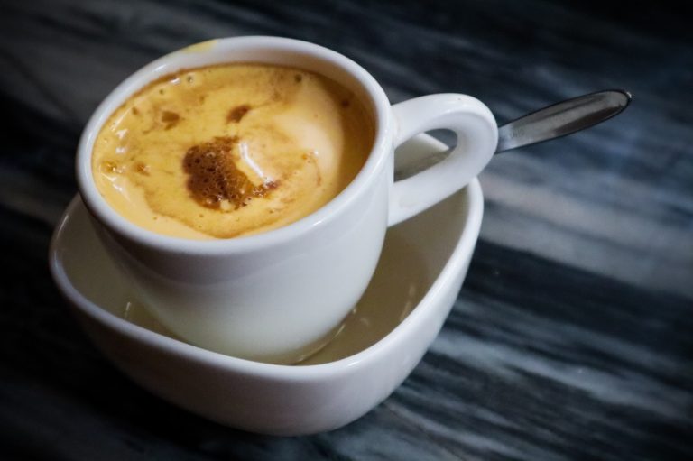 Traditional Hanoi egg coffee served in a white cup with a thick creamy topping