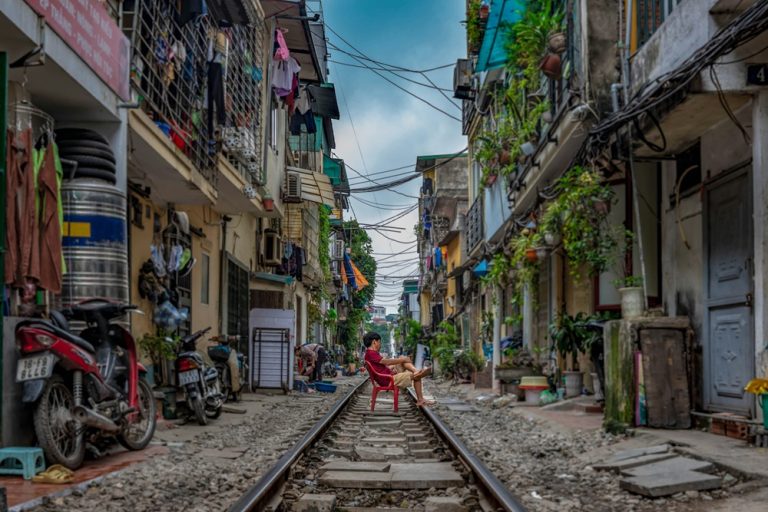 Hanoi Train Street with homes built beside the railway, illustrating Vietnam travel tips for visiting one of the city's most famous attractions safely.