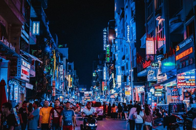Crowds, motorbikes and neon lights along Bui Vien Walking Street at night in Ho Chi Minh City Caption: Description: