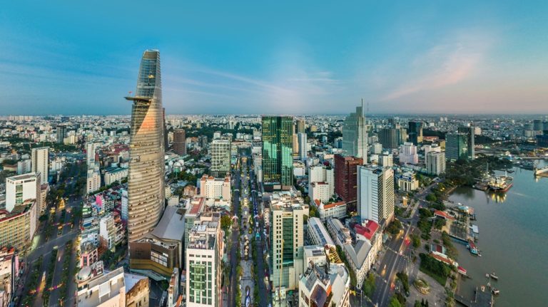 Skyline of Ho Chi Minh City at sunset featuring the iconic Bitexco Financial Tower and the Saigon River Caption Description