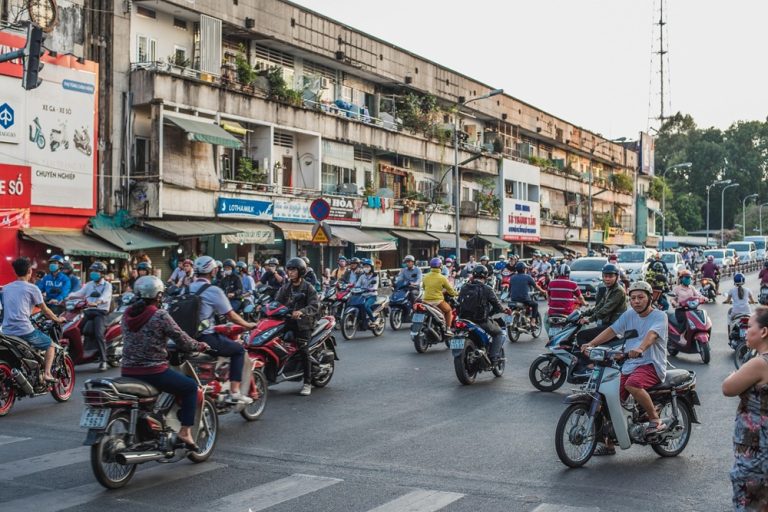 Busy Ho Chi Minh City intersection filled with motorbikes, scooters and cars during rush hour