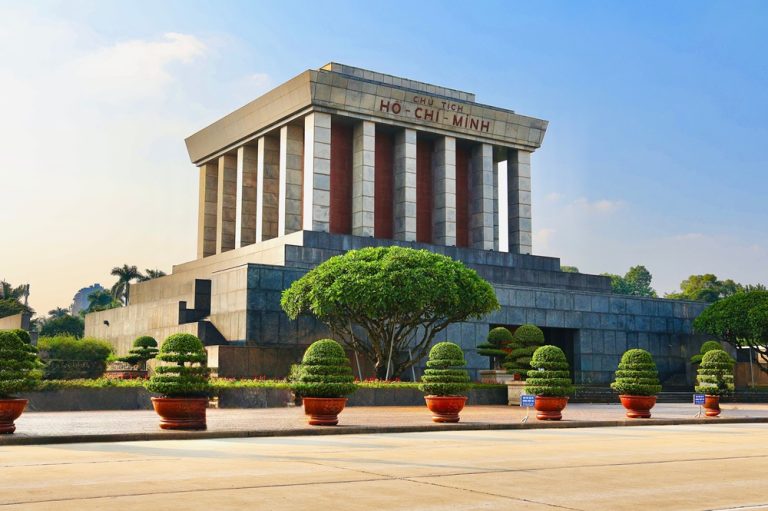 Ho Chi Minh Mausoleum surrounded by manicured trees and gardens in Ba Dinh Square, Hanoi