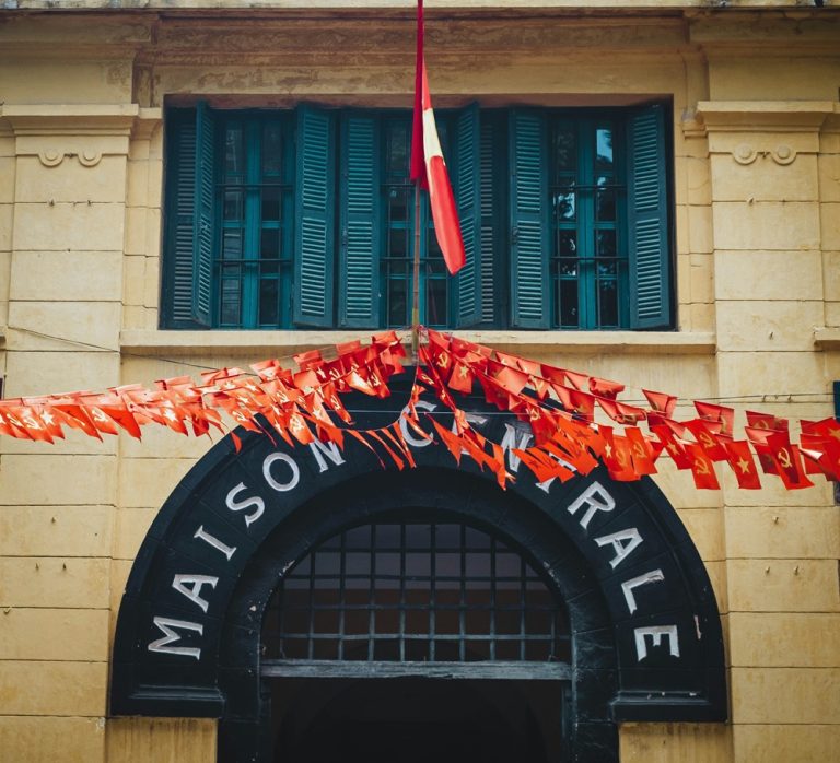 Entrance to Hoa Lo Prison in Hanoi decorated with Vietnamese flags
