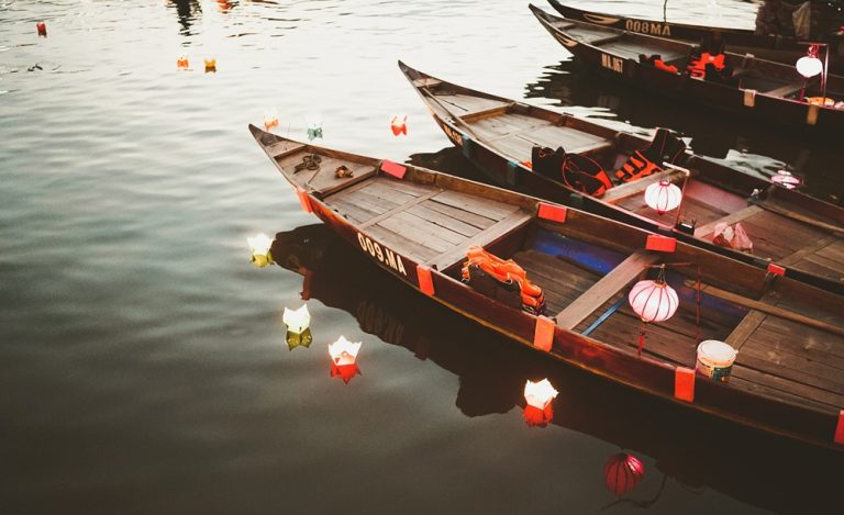 Things to do in Hoi An include seeing traditional lantern boats and floating lanterns on the Hoai River after dark. Caption Description