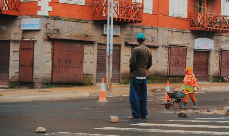 Street scene with pedestrians and a road worker in Antananarivo, Madagascar