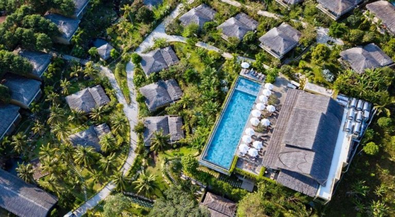 Aerial view of Lahana Resort Phu Quoc & Spa surrounded by tropical gardens, private bungalows and a large swimming pool in the heart of Phu Quoc Island.