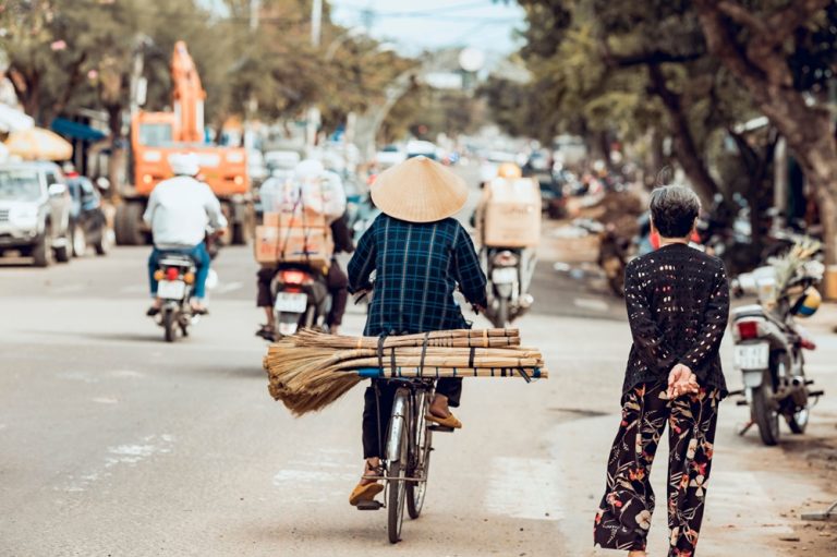 Getting around Vietnam by bicycle on a busy city street Caption Description