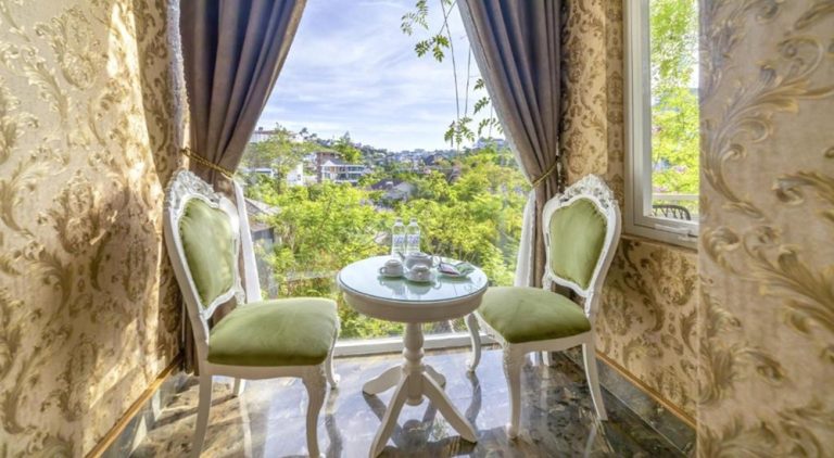 Elegant seating area at Mac Valley DaLat Hotel overlooking the hills of Da Lat, offering a peaceful setting with scenic views of the surrounding countryside.