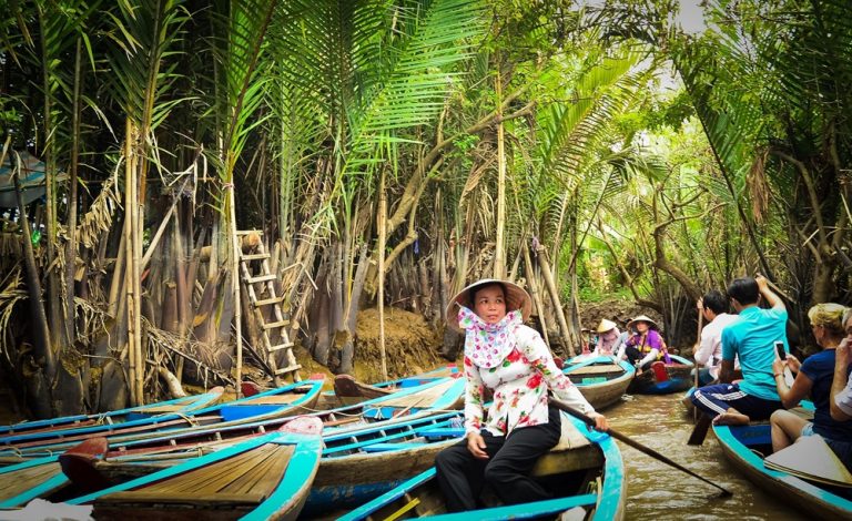 Traditional sampan boats travelling through narrow canals in the Mekong Delta