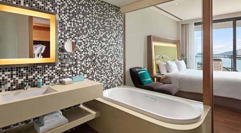 Modern guest room and bathroom at Novotel Danang Premier Han River in Da Nang, Vietnam