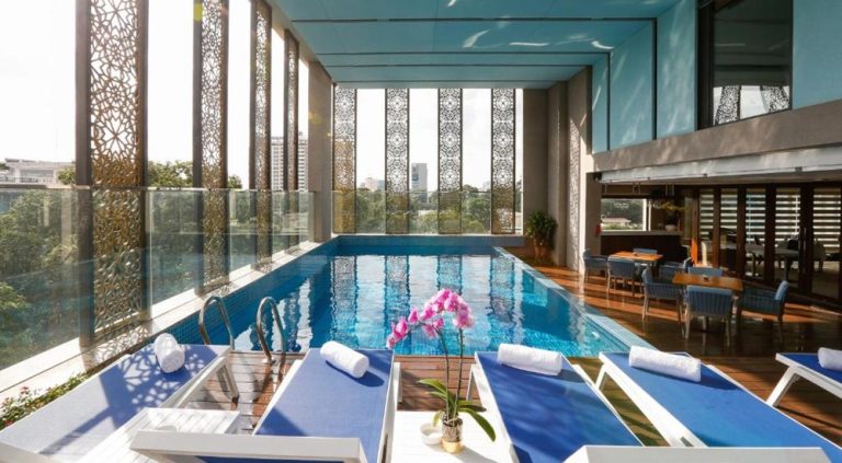 Indoor swimming pool and sun loungers at Orchids Saigon Hotel in Ho Chi Minh City