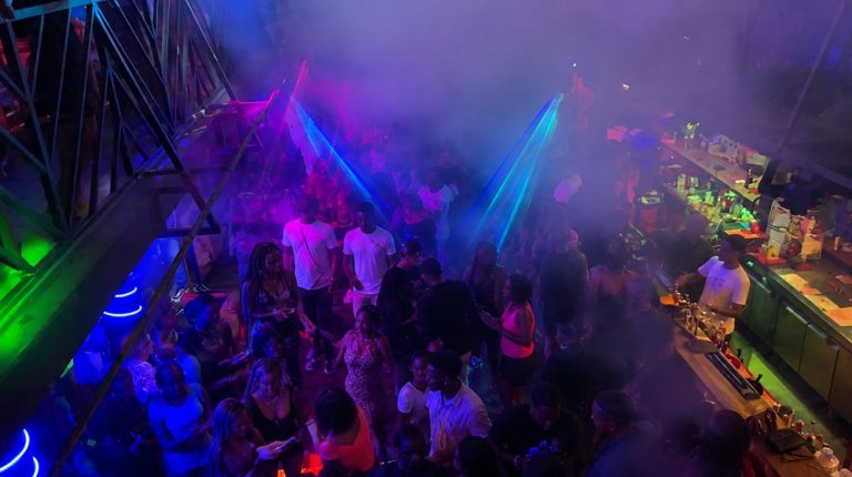 Crowded dance floor with colorful lights and lasers inside Taxi Be nightclub in Antananarivo, Madagascar