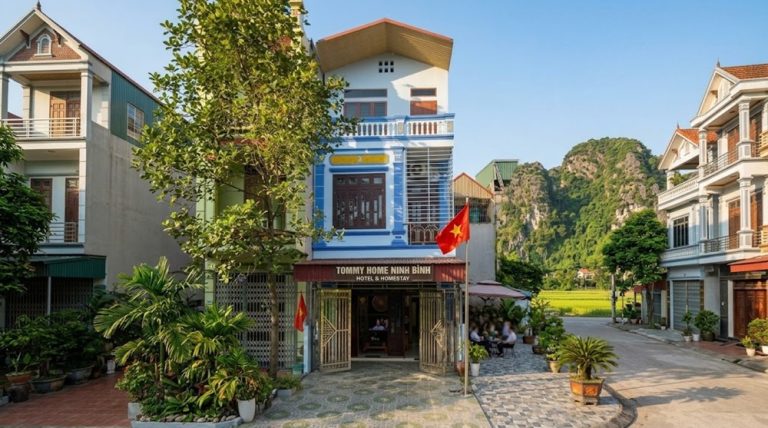 Exterior of Tommy Home Ninh Binh Hotel with limestone mountains and rice fields nearby Caption: Description: