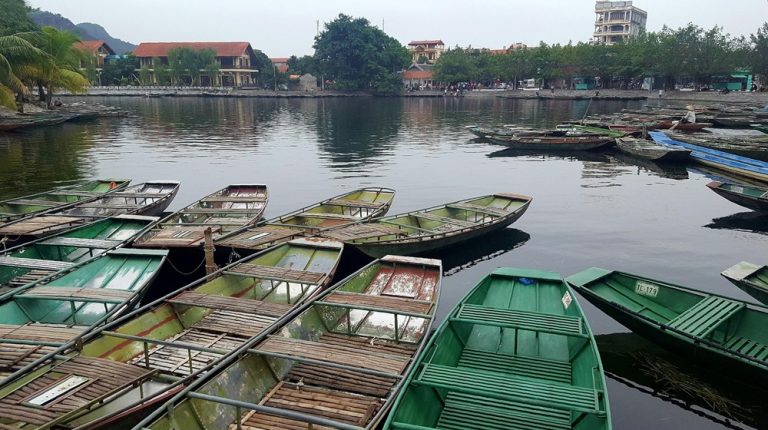 Traditional rowing boats moored along the waterfront at Tam Coc in Ninh Binh