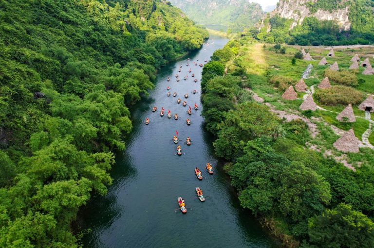 Boats travelling along the river through the limestone karst landscape of Trang An in Ninh Binh Caption: Description: