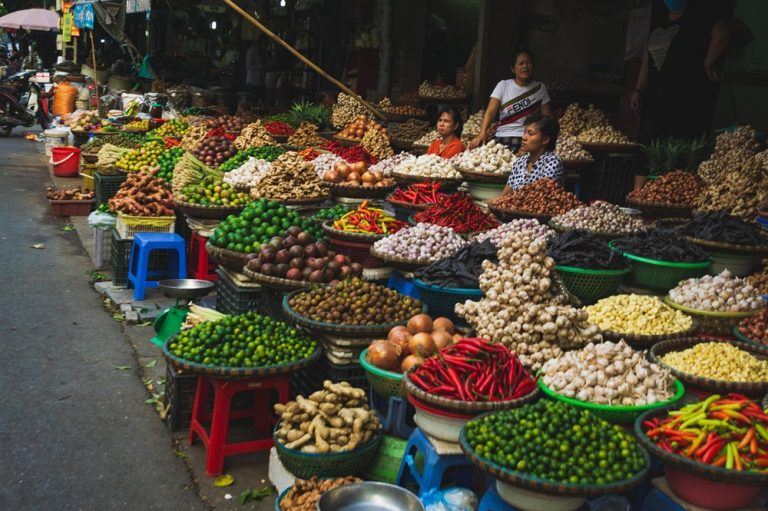 Traditional Vietnamese market with stalls selling fresh fruit, vegetables, herbs and spices