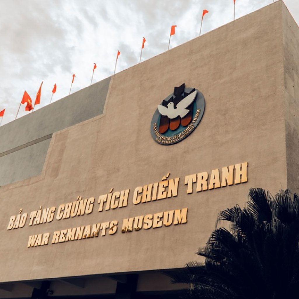 Exterior of the War Remnants Museum in Ho Chi Minh City with Vietnamese flags above the entrance