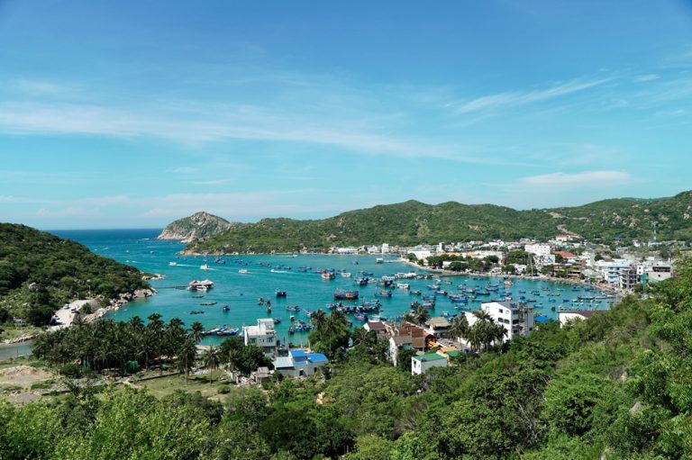 Fishing boats gathered in a turquoise bay surrounded by green hills near Nha Trang, Vietnam