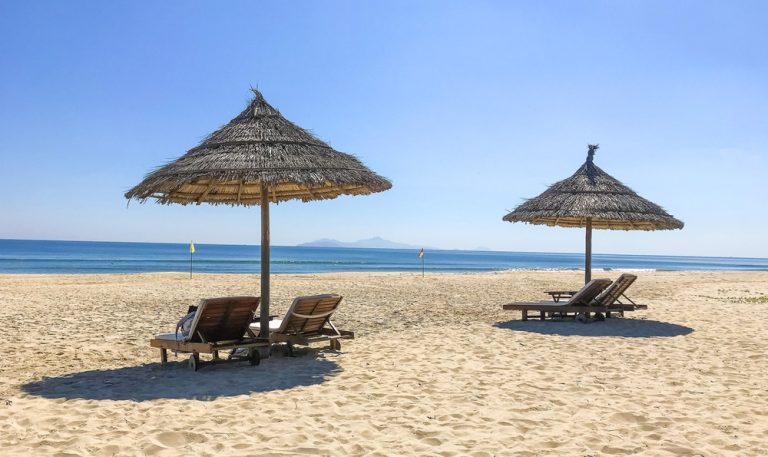 Doc Let Beach near Nha Trang with golden sand, thatched umbrellas, sun loungers and calm blue sea