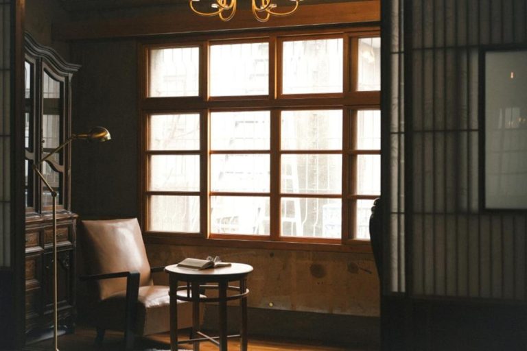 Warm traditional-style interior with wooden windows and seating at FunNan Guesthouse in Tainan