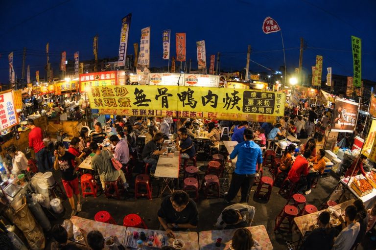 Crowded Garden Night Market in Tainan with illuminated food stalls and diners at night Caption Description
