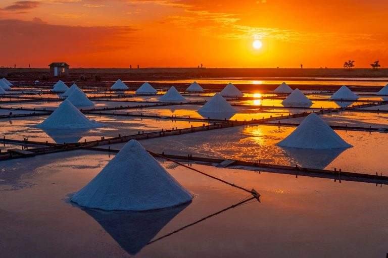 Salt mounds reflecting the orange sunset at Jingzaijiao Tile-Paved Salt Fields in Tainan