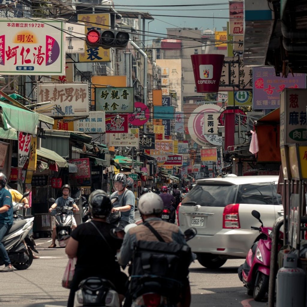 Busy street in Tainan with scooters, shops and traditional Chinese signs