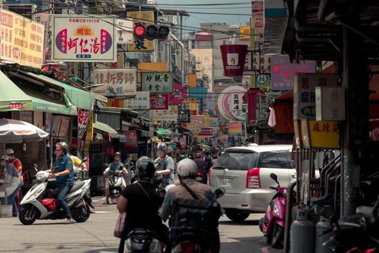 Busy street in Tainan with scooters, shops and traditional Chinese signs