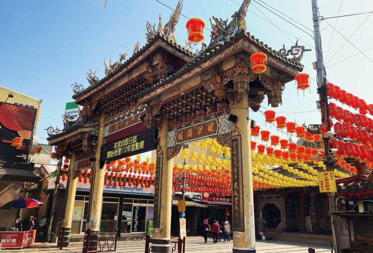 Traditional temple gate decorated with red and yellow lanterns in Tainan Caption Description