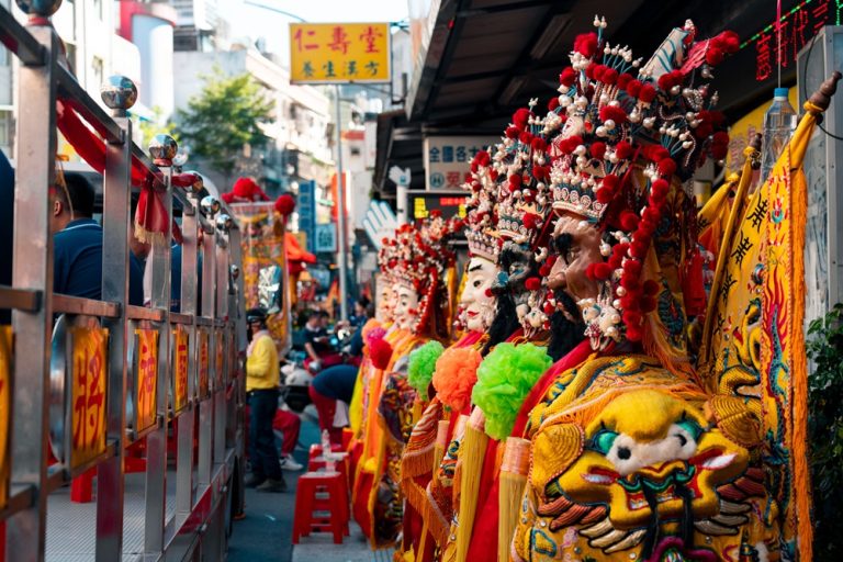 Colourful traditional deity figures in elaborate ceremonial costumes during a religious celebration in Tainan
